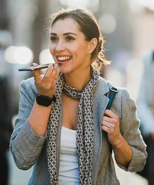 Woman using VoicePay on WhatsApp to make a secure payment with a voice command